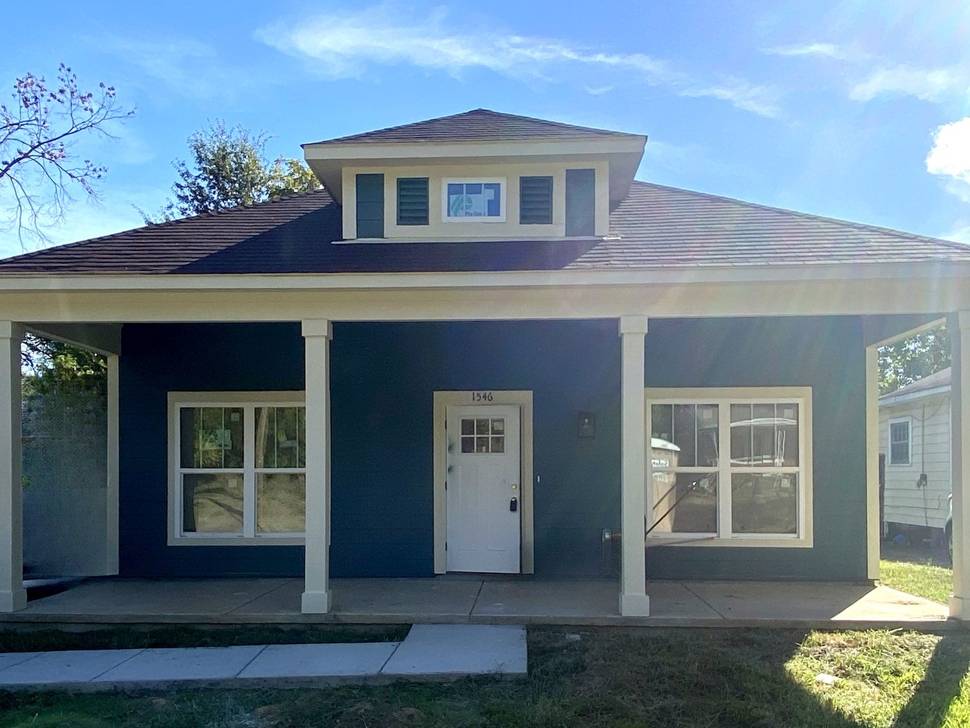 Front of 1546 Humber, a new blue house with a hip roof, center dormer, and full front porch