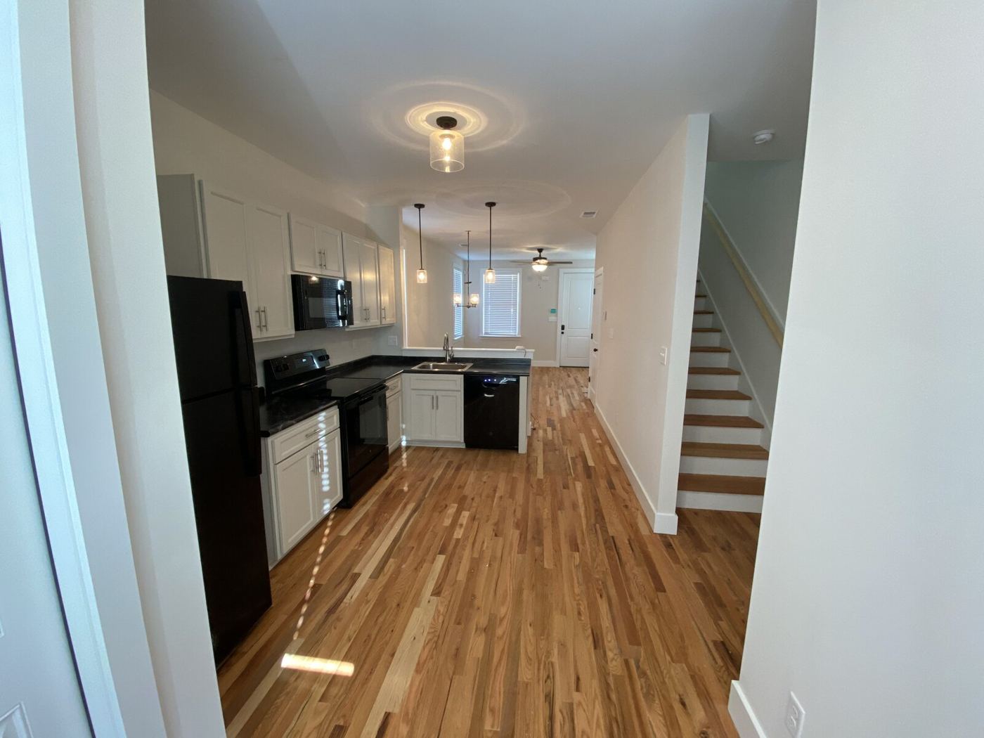 Kitchen and living area inside a two-bedroom Jones Urban cottage with hardwood floors